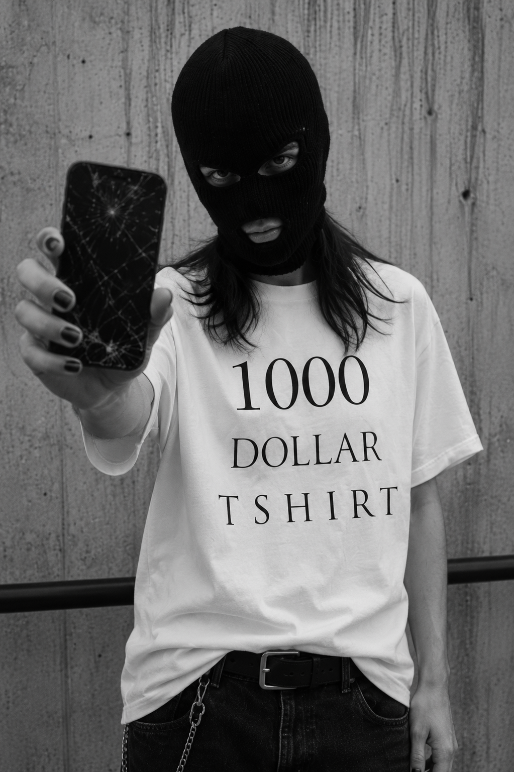 Model wearing the $1,000 plain white t-shirt holding a cracked iPhone — 1000DOLLARTSHIRT conceptual luxury