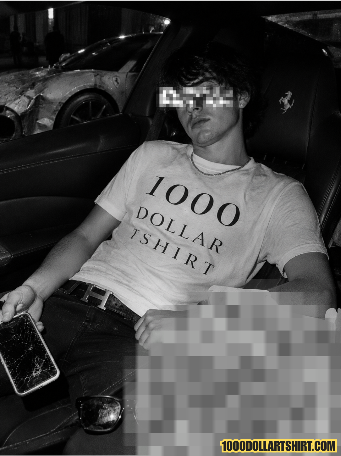 Black and white documentary-style photograph of a young man wearing a 1000 Dollar T Shirt while sitting inside a luxury sports car, holding a cracked smartphone with a damaged Ferrari parked outside.